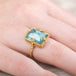 Gold ring with a large aquamarine gemstone on a person's finger