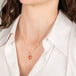 Gold necklace with a fire opal gemstone on a person