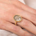 Gold ring with a dendritic quartz stone on a hand