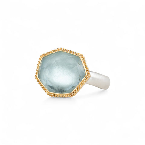 Aquamarine ring with 18k gold bezel and sterling silver band on white background