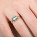 Gold ring with a moonstone gemstone on a person's finger