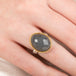 Ring with gray quartz stone, gold bezel and silver band on a person's finger