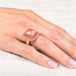 Gold and silver ring with pink guava quartz stone on a hand