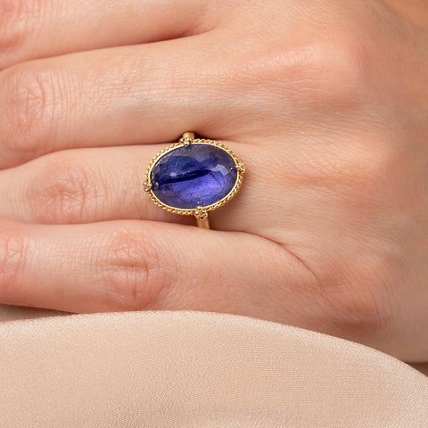Gold ring with a tanzanite gemstone on a hand