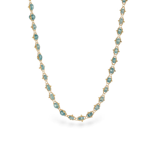 Gold necklace with kornerupine gemstones on a white background