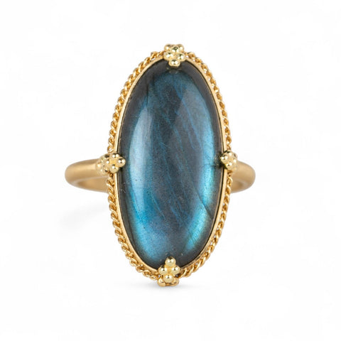 Gold ring with a labradorite stone on a white background