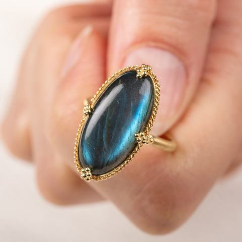 Close up of a gold ring with a labradorite stone