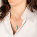 Teardrop-shaped labradorite pendant necklace on a person wearing a white shirt