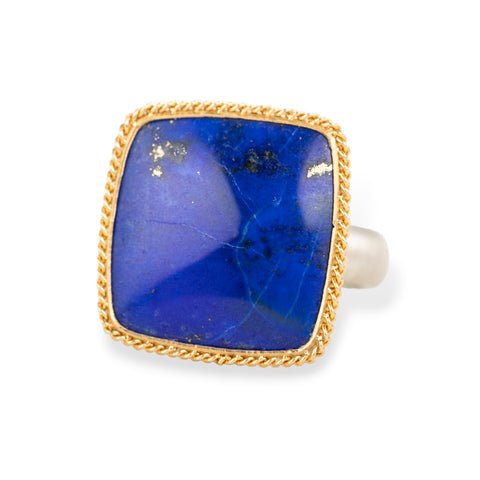 Ring with lapis stone, gold setting and silver band on a white background