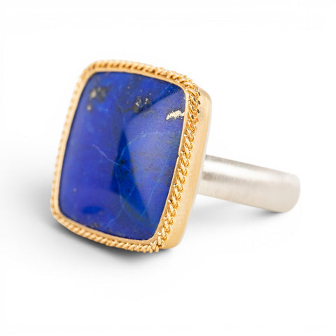 Ring with lapis stone, gold setting and silver band on a white background
