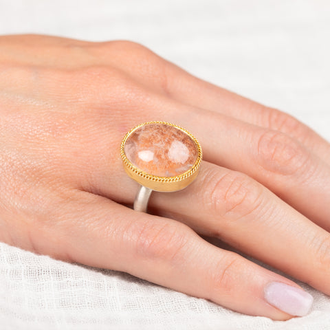 Ring with gold bezel, silver band and lodolite stone on a hand