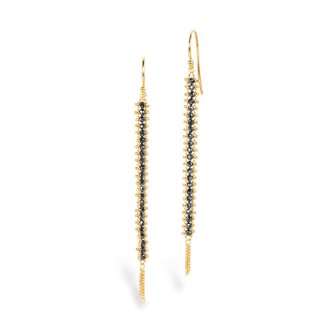 A pair of gold drop earrings with a row of black diamonds, shown against a plain white background.