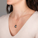 Gold necklace with a mabe pearl pendant on a person's neck