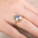 Gold ring with a mabe pearl on a person's finger