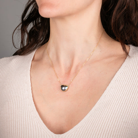Necklace with a mabe pearl pendant on a person's neck