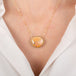 Gold necklace with a large Mexican opal stone on a person