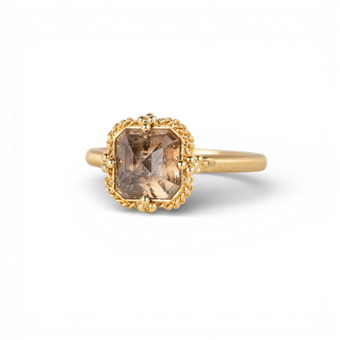 Gold ring with a diamond gemstone on a white background
