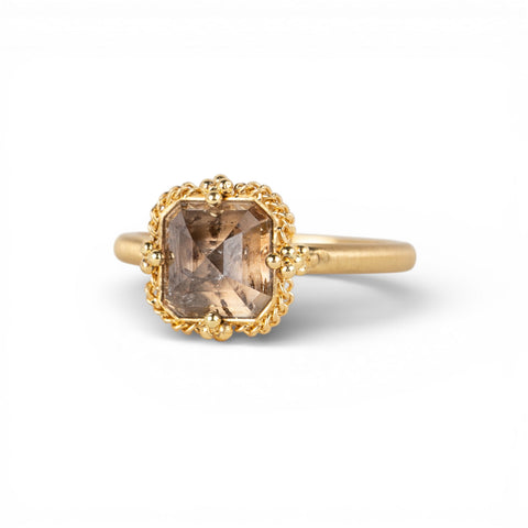 Gold ring with a diamond gemstone on a white background