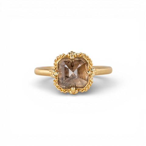 Gold ring with a diamond gemstone on a white background