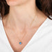 Necklace with a moon face moonstone pendant worn by a person