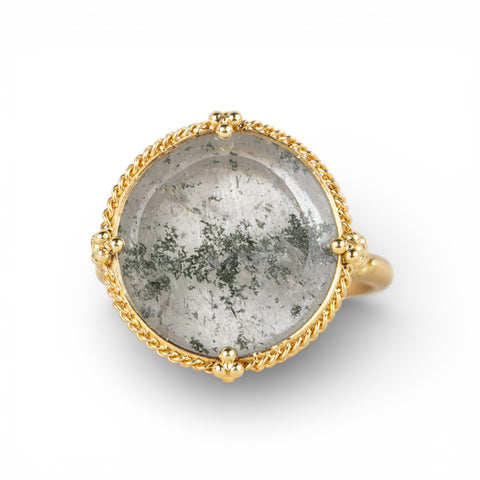 Ring with gold band and gray topaz stone on a white background