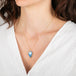 Necklace with a moonstone worn by a person in a white top