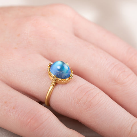 Gold ring with a moonstone gemstone on a hand
