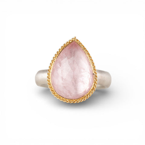 Gold and silver ring with pink morganite teardrop-shaped gemstone on a white background