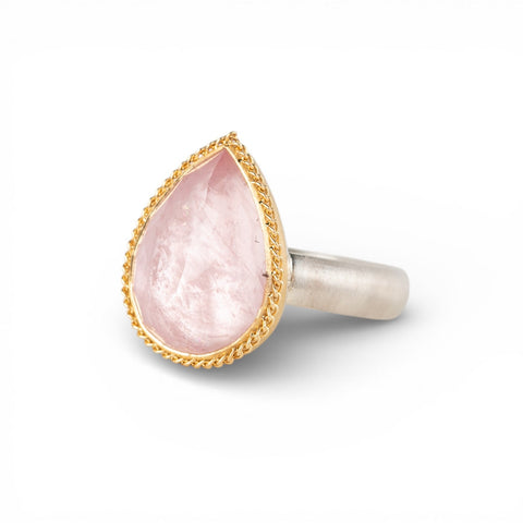 Gold and silver ring with pink morganite teardrop-shaped gemstone on a white background