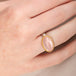Ring with morganite stone, gold bezel and silver band on a person's finger