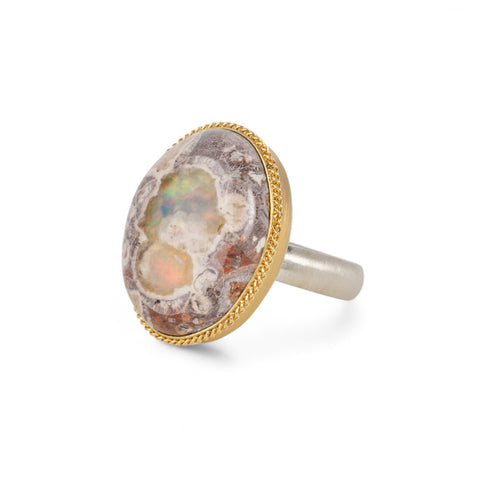 Handmade ring with a Mexican Opal stone set in an 18k gold bezel with a sterling silver band