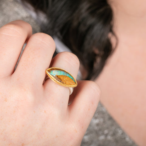 Ring with an opal stone, gold setting and silver band on a hand
