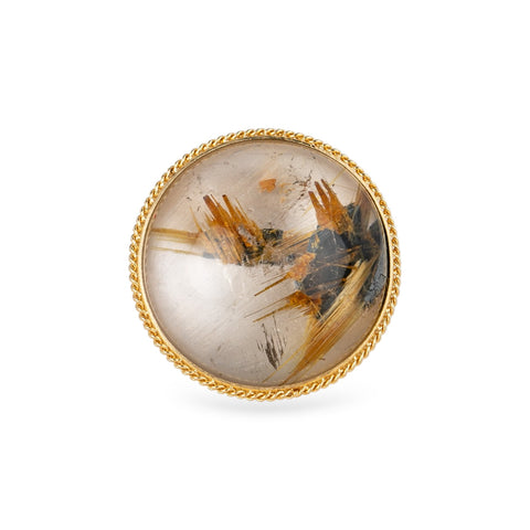 The face of a ring with rutilated quartz set in an 18k gold bezel, with a sterling silver band