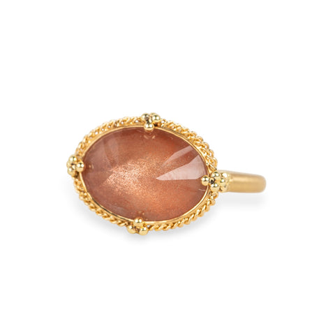 Gold ring with an Oregon sunstone on a white background