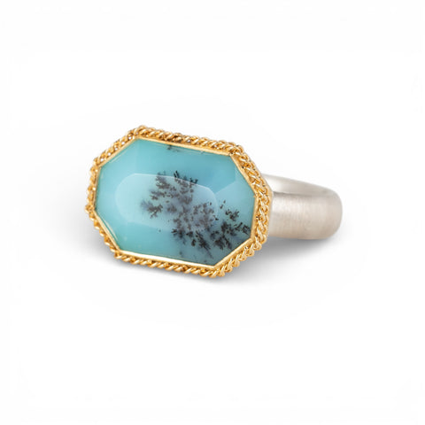 Gold and silver ring with peruvian opal stone on a white background