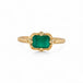 Gold ring with an emerald gemstone on a white background