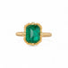 Gold ring with an emerald gemstone on a white background