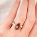 Hand wearing a pink tourmaline ring with gold bezel and silver band