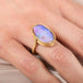 Gold ring with a colorful boulder opal gemstone on a hand