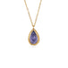 Gold necklace with a tanzanite teardrop pendant on a white background