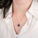 Tanzanite pendant on a gold chain against a person