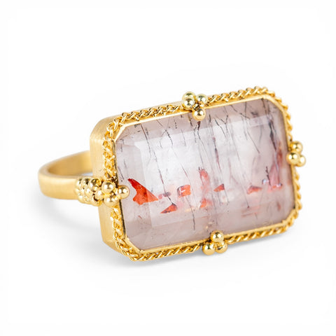 Gold ring with a Super 7 stone on a white background