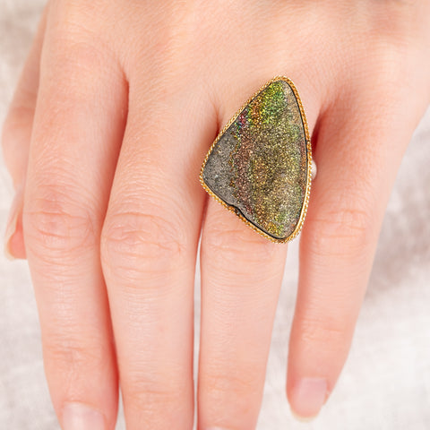 Hand wearing a Rainbow Pyrite Druzy ring with gold bezel and silver band