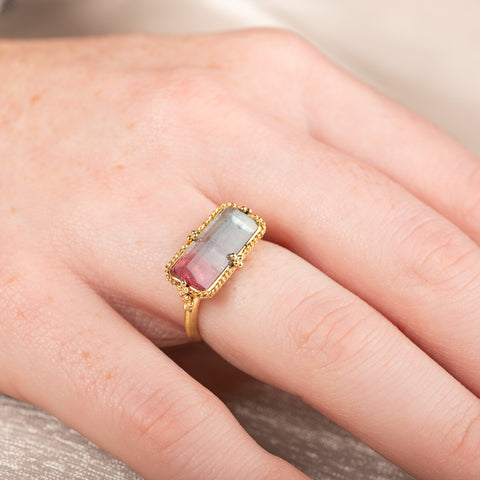 Handcrafted gold ring with a watermelon tourmaline gemstone worn on a hand