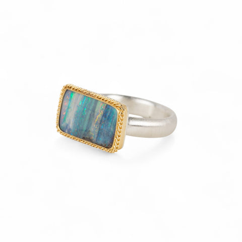 Handmade fine jewelry boulder opal ring with an 18k gold bezel and sterling silver band