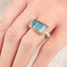 Close up of person wearing a handmade fine jewelry boulder opal ring with an 18k gold bezel and sterling silver band
