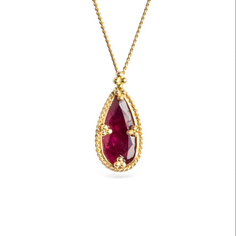 Gold necklace featuring a ruby gemstone on a white background