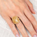 Gold and silver ring with a rutilated quartz stone on a hand