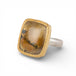Gold and silver ring with a rutilated quartz stone on a white background