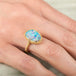 Gold ring with a colorful boulder opal gemstone on a hand